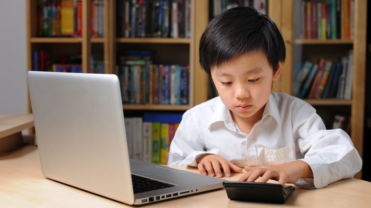 Boy learning math with computer and calculator