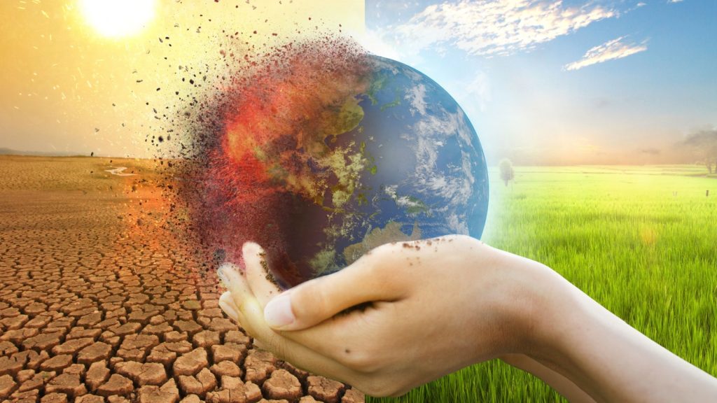 Hand of young man hold world globe with burn hot by drought environment and beautiful green abundance nature metaphor Climate change.