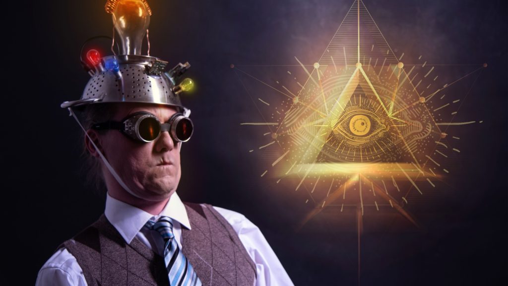 conspiracy believer in suit with aluminium foil head and illuminati sign