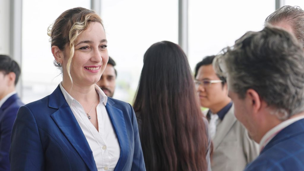 Smiling face of Caucasian businesswoman in suit talking with partner at seminar of company. Confident businesswoman manager.