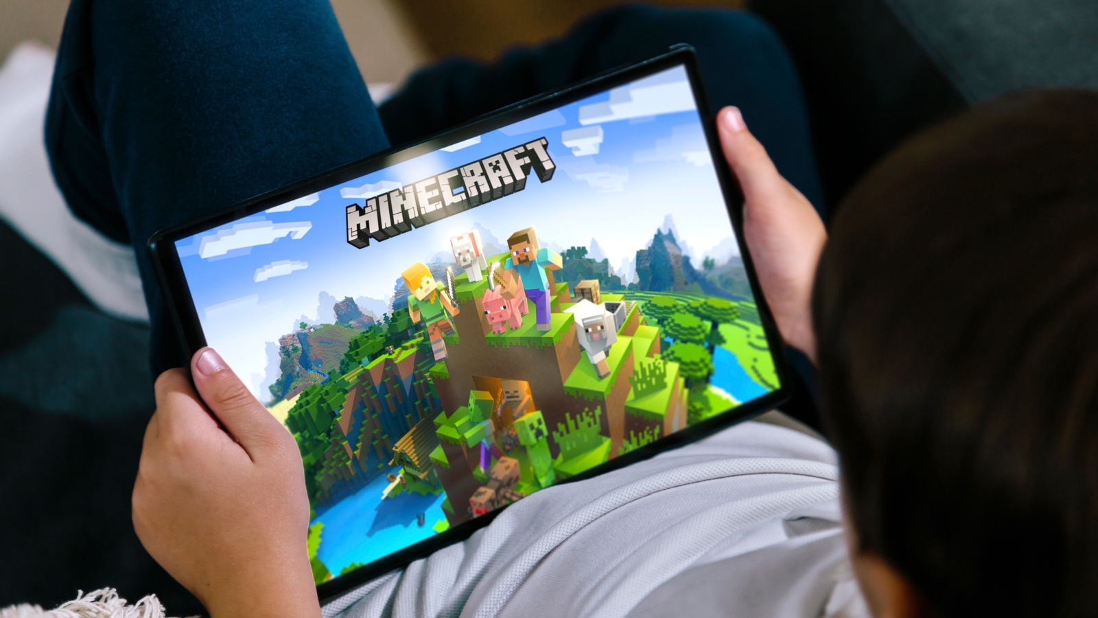 Little boy playing Minecraft game on a tablet. Minecraft is a very popular game among children and teenagers. 