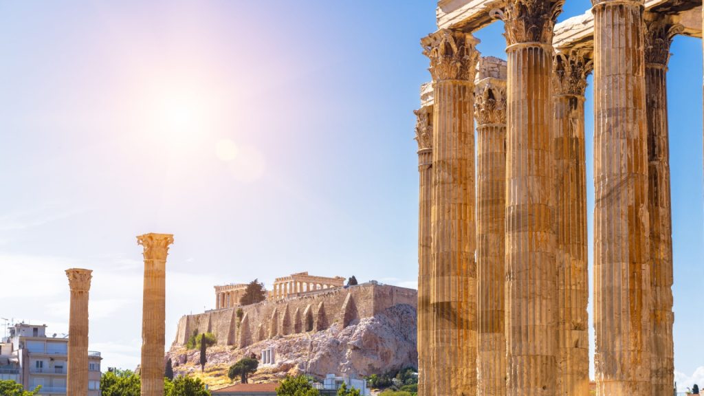 Zeus temple overlooking Acropolis, Greece. Ancient Greek ruins, famous landmarks of Athens city. Scenery of great columns of classical building in Athens center. Travel in Greece theme.