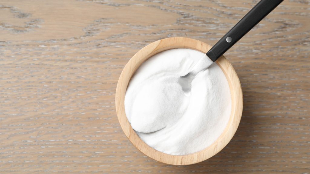 Baking soda in bowl on wooden table, heartburn, remedy.