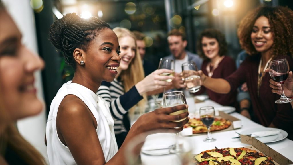 Diversity, dinner and group of people toast celebration together at party. Friends, happy and celebrate with food, wine and friendship for love, support and cheers champagne at business function.