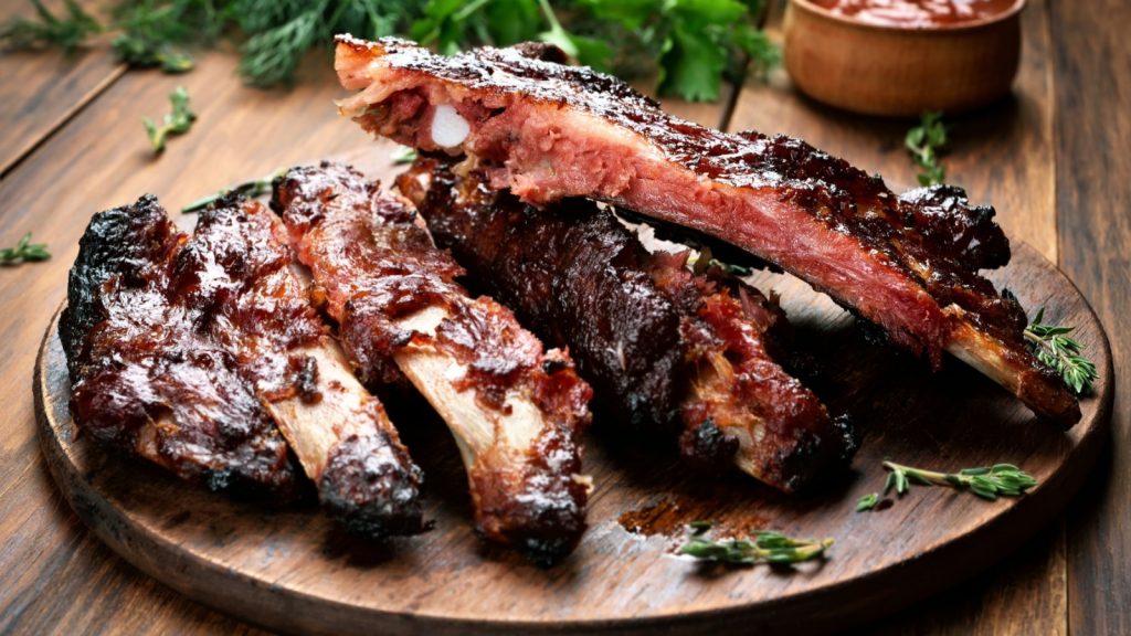 Roasted sliced barbecue pork ribs, focus on sliced meat.