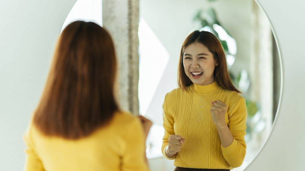 An Asian woman looking at the mirror