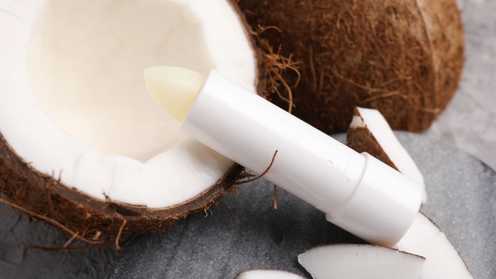 Lip balm and coconut on grey table