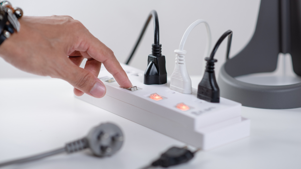 Hand on a power strip with switches