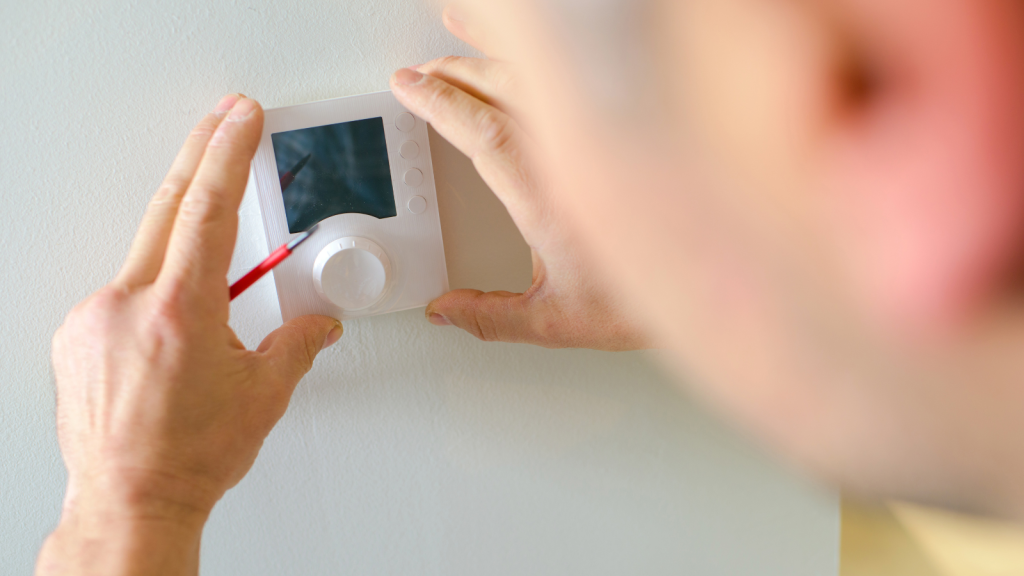 Person holding a thermostat control