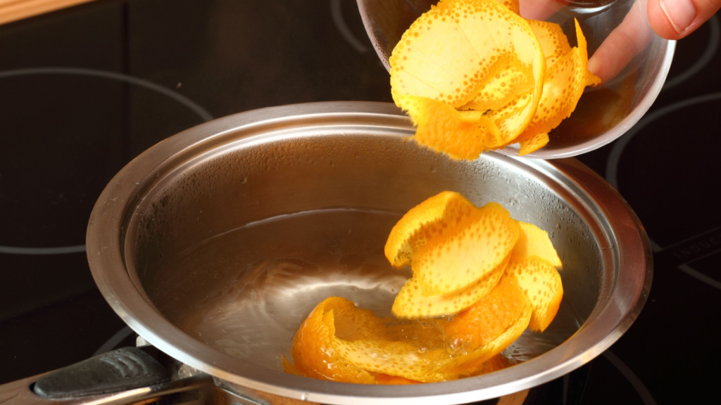 Adding orange peel into saucepan with boiling water