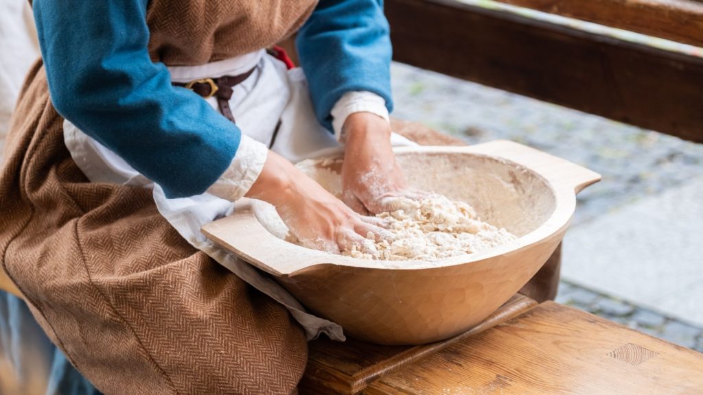 a medieval female baker making bread
