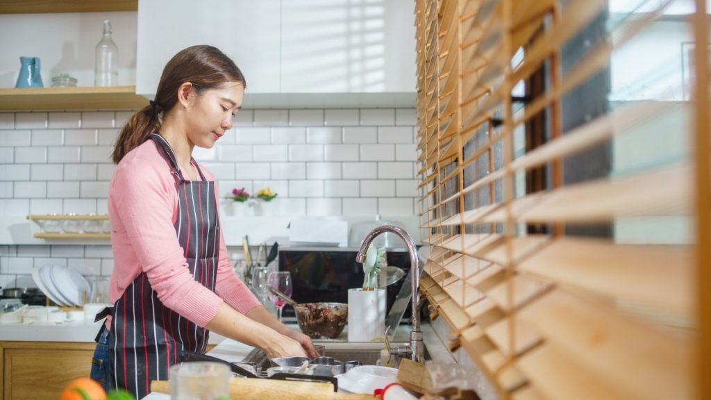 woman cleaning kitchen after cooking