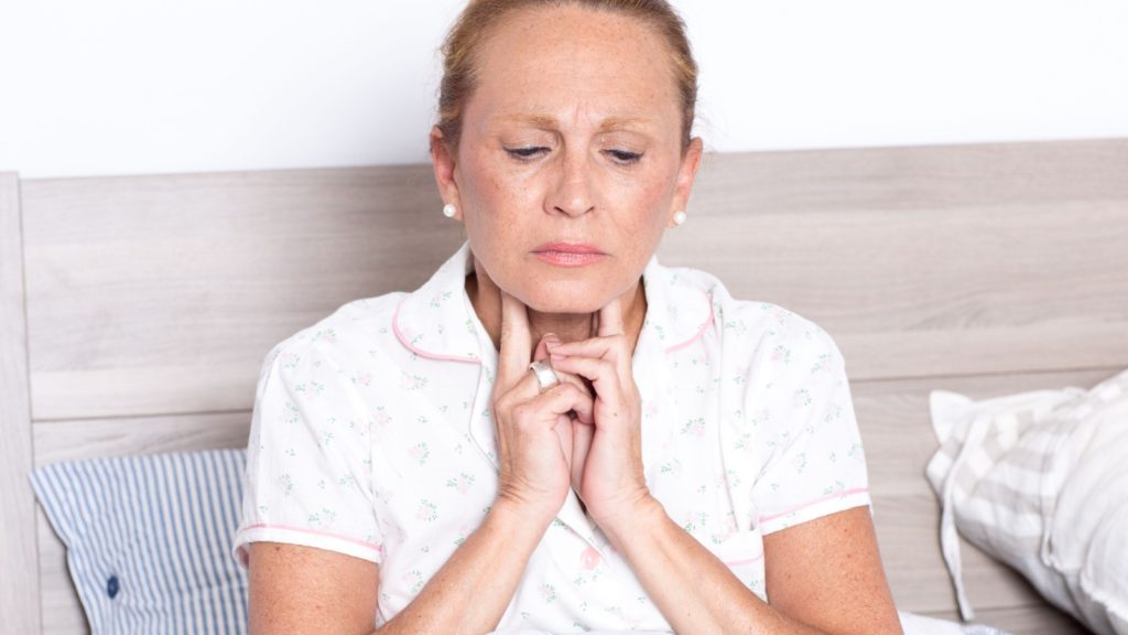 older woman checking her throat