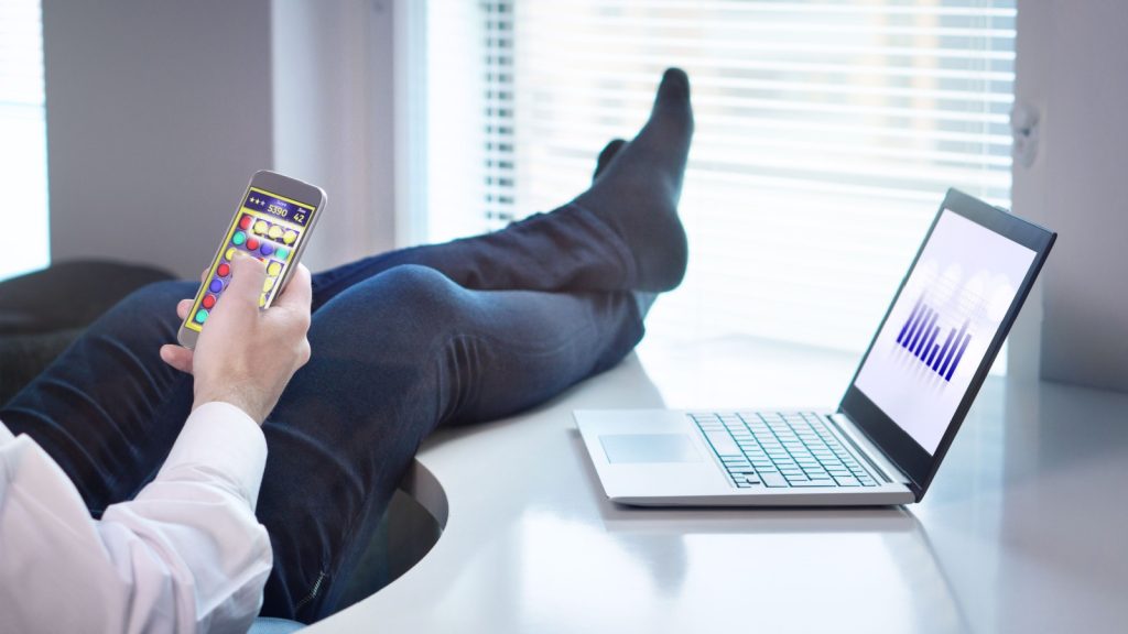 Man relaxing while playing mobile game