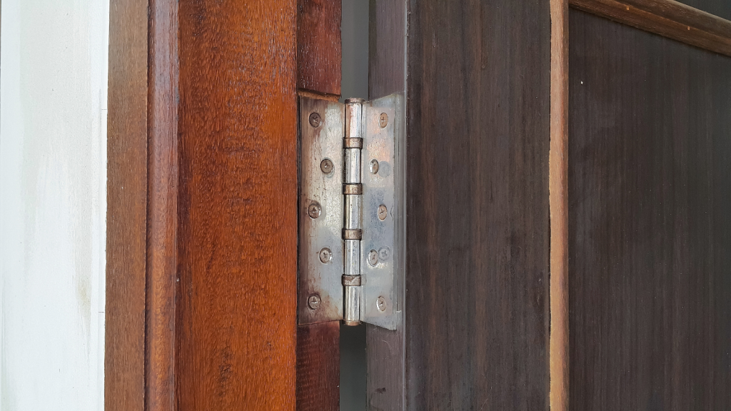 Stainless door hinges on wooden swing door