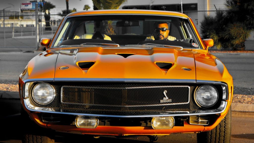 Orange Shelby GT500 with a driver inside