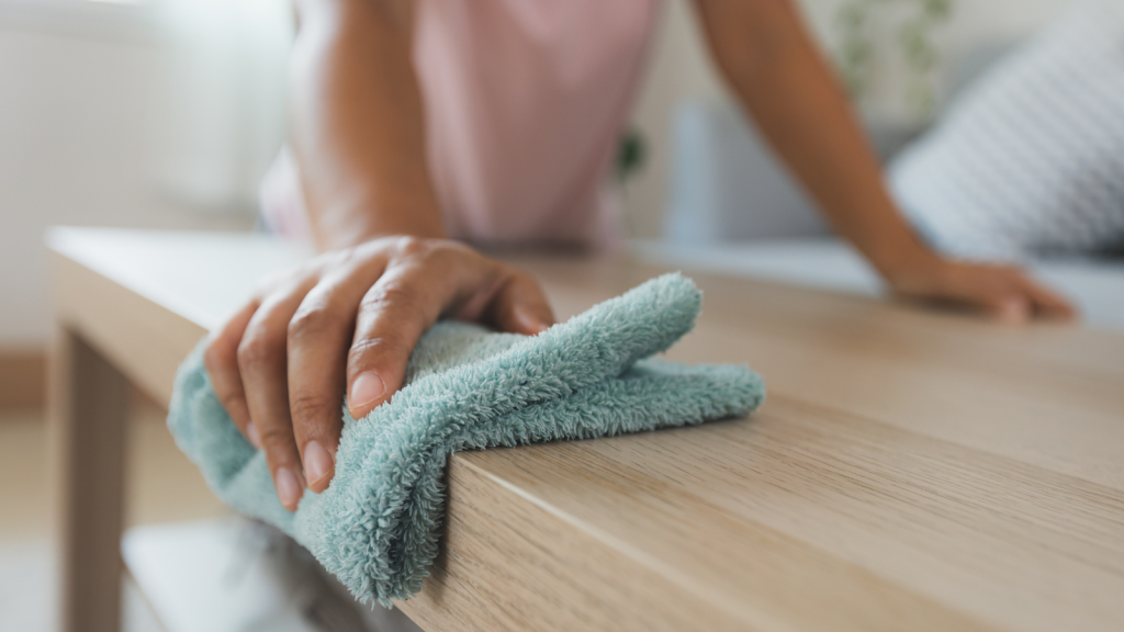 Woman cleaning and wiping the table with microfiber cloth in the living room