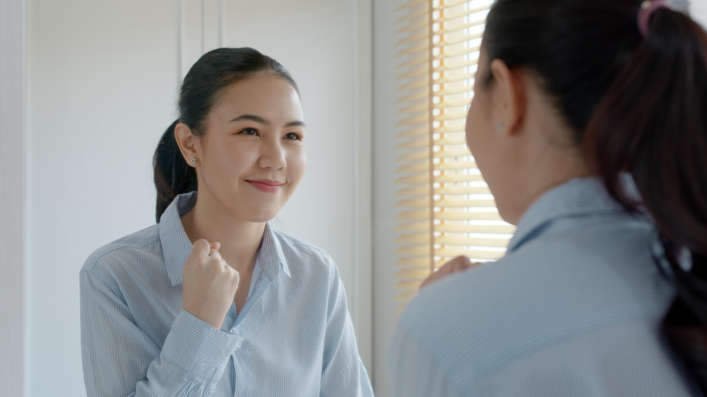 Young adult female infront of mirror feeling confident