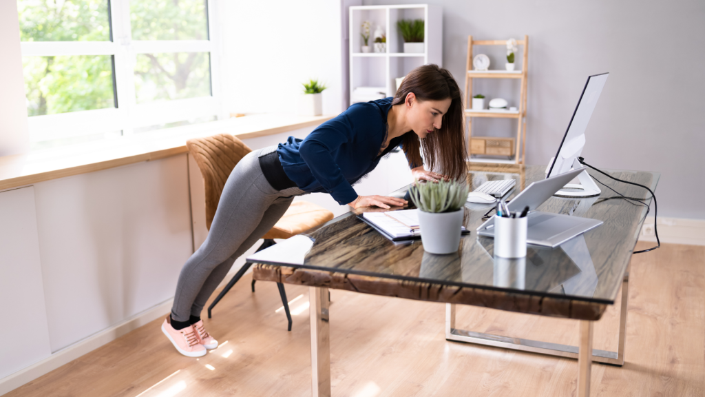 Woman doing push up on her office desk