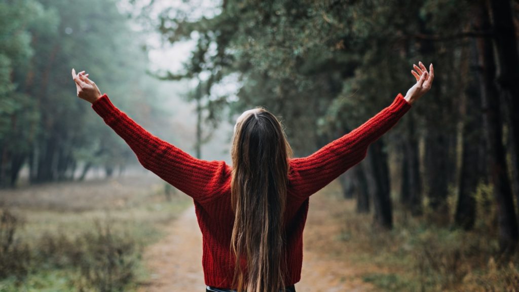 Woman embracing nature, casting negativity away