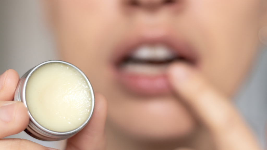 woman applying lip balm or scrub from natural ingredients