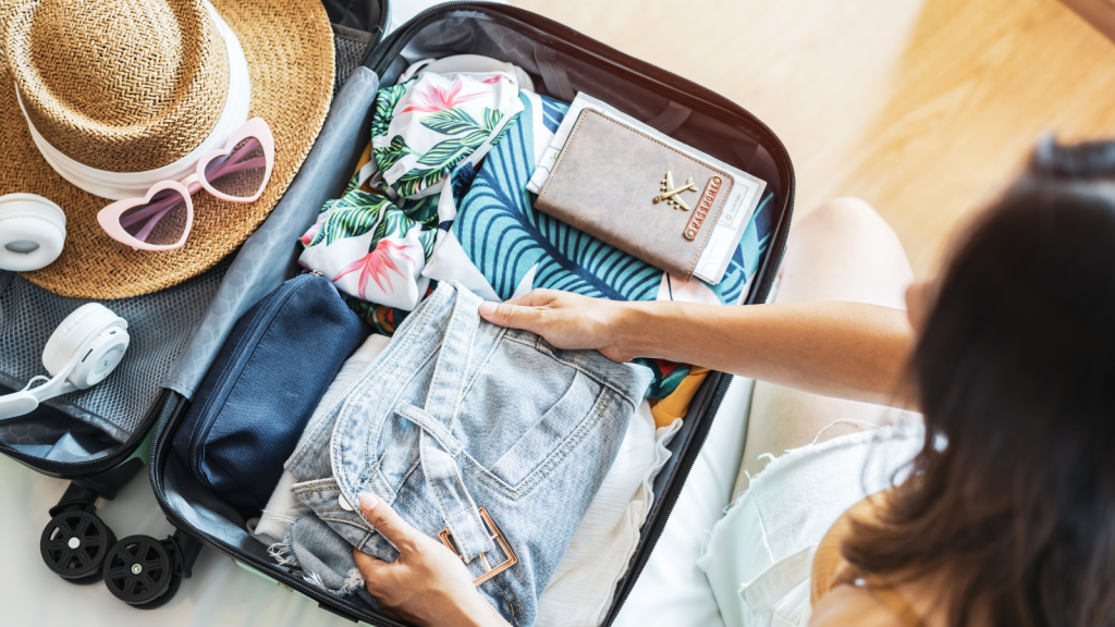 woman traveler sitting on the bed packing her suitcase preparing for travel