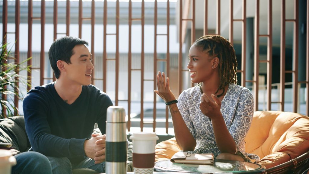 A man and a woman having a conversation in a coffee shop