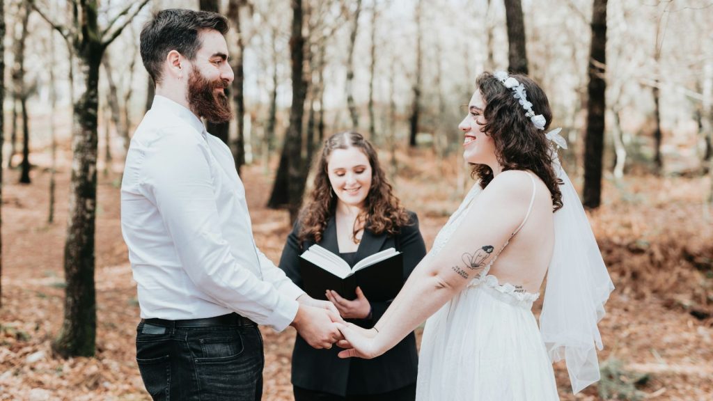 A man and woman holding hands during a wedding ceremony