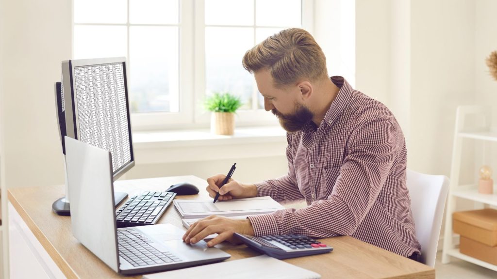 A man doing tasks sitting in an office desk