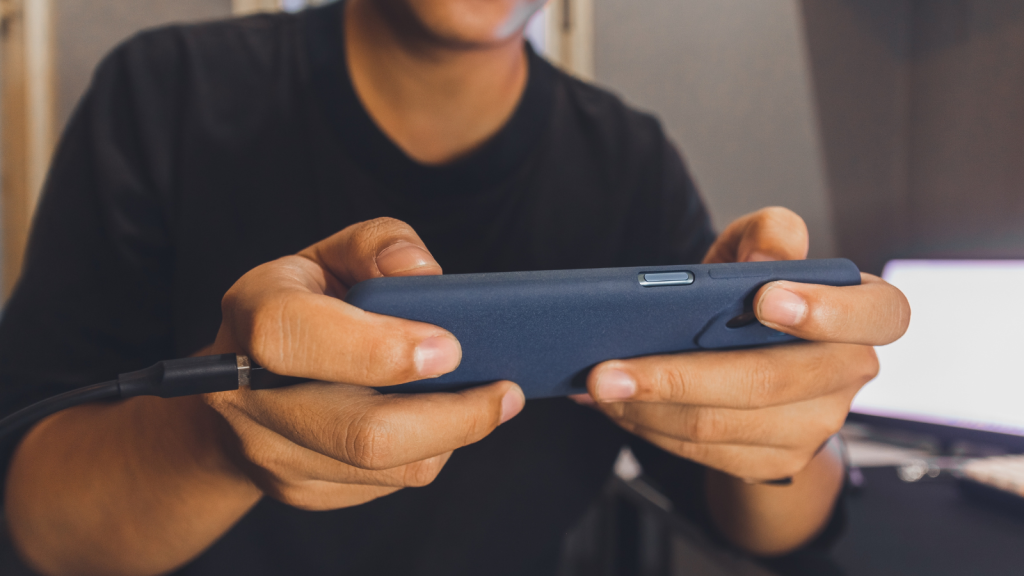 A man playing game on the phone while charging