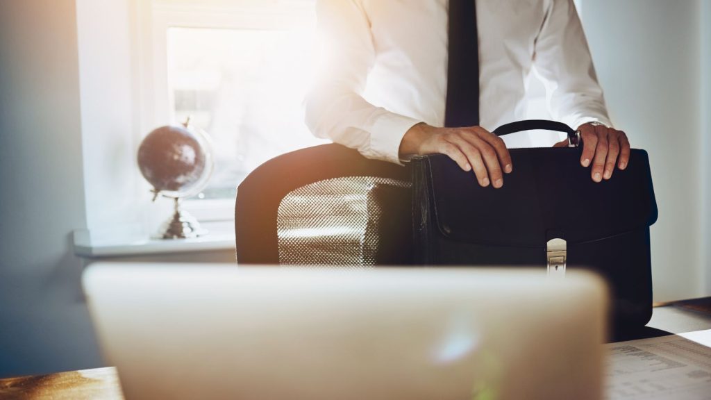 A man standing at desk with briefcase