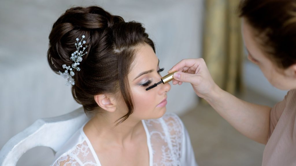 A woman applying makeup of the bride