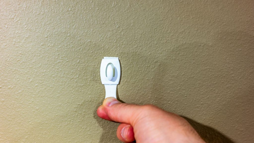 Adhesive strip wall hanger that can be removed by pulling tape