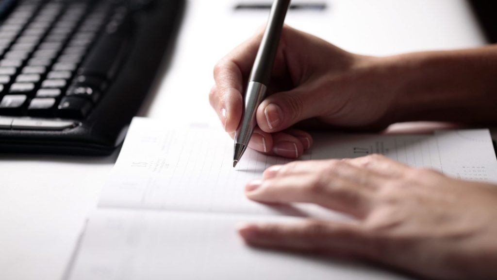 An image of woman's hand while updating her to-do list