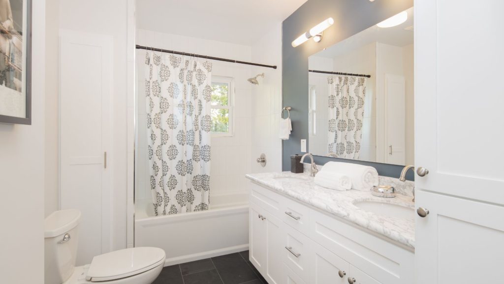 Bathroom with double oval marble sink and shower curtain