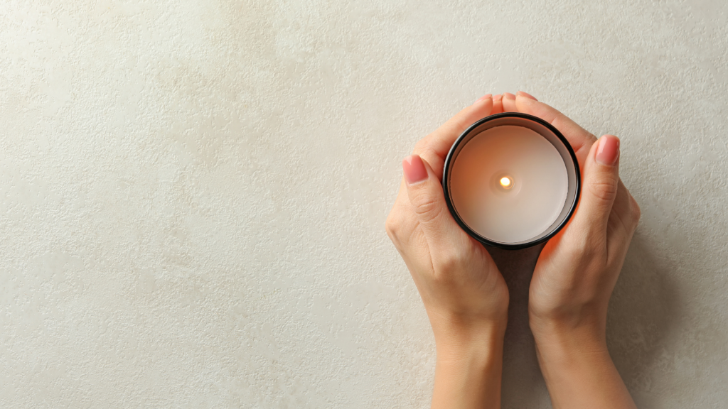 Female hands holding scented candle, top view