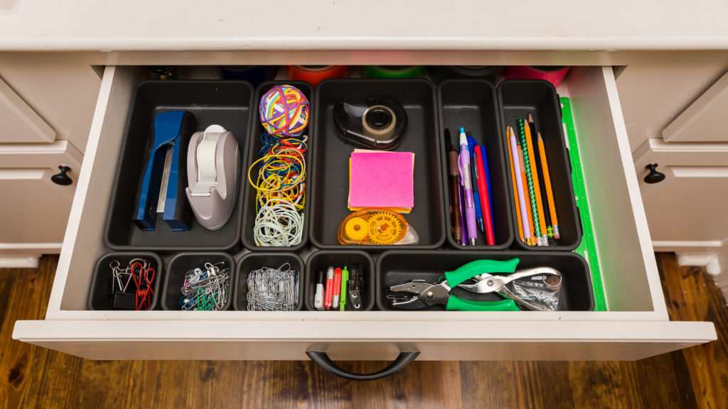 Image of a neatly organized desk featuring several trays used to store office supplies