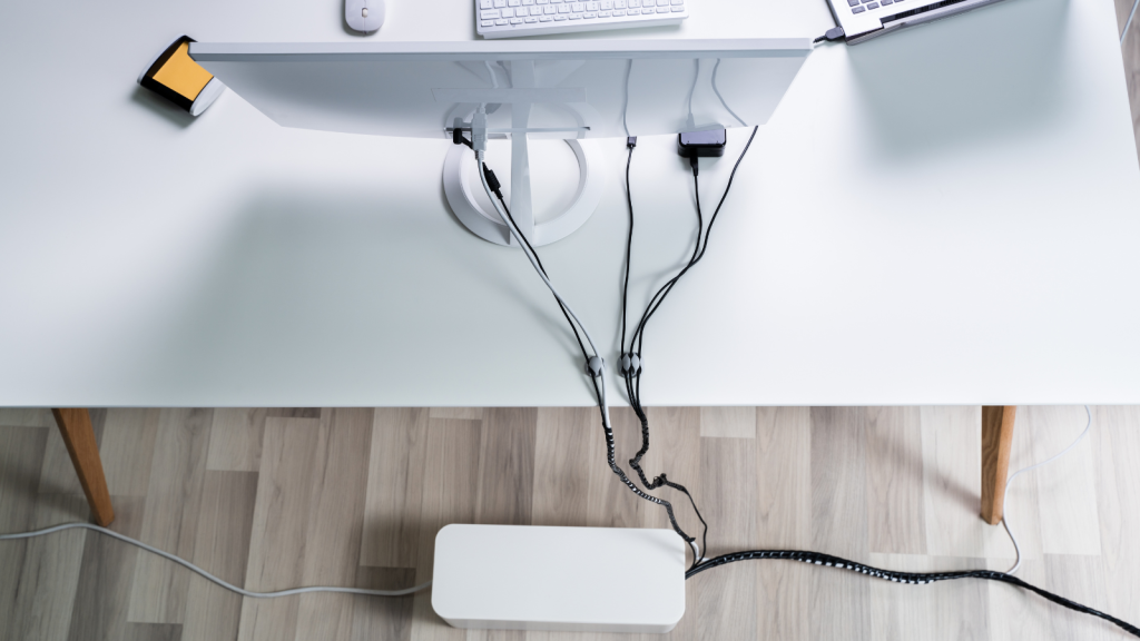 Image of a tidy desk setup with a cable organizer neatly holding various cables in place