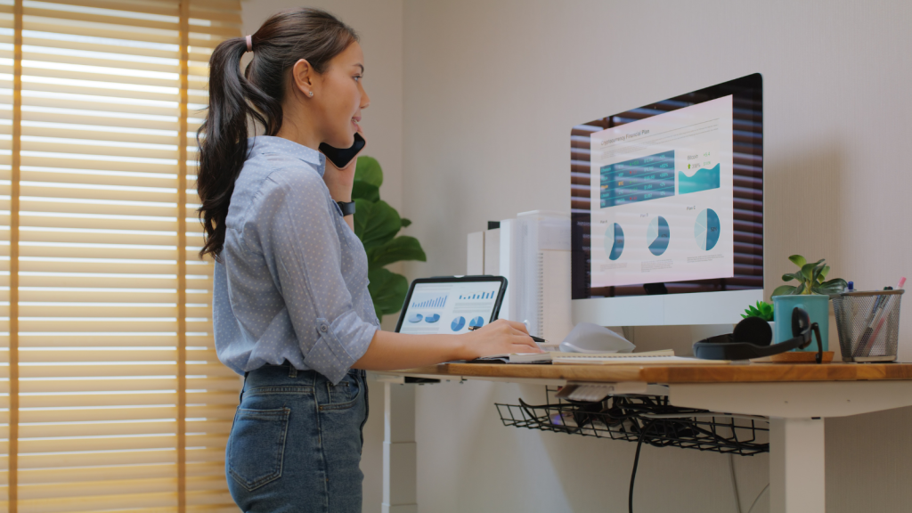 Image of a woman in a modern standing desk setup in a bright, ergonomic workspace