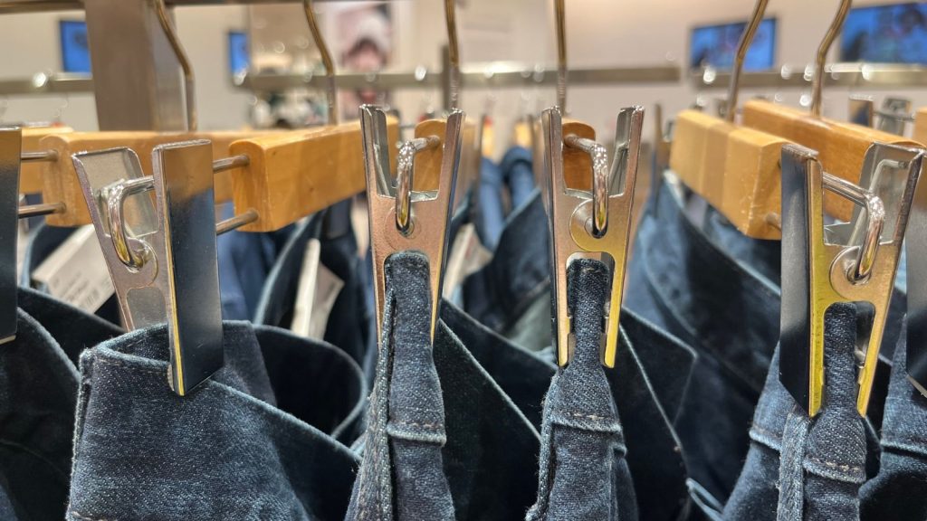 Image of a closet rod with several pairs of trousers hanging from the bottom bar of a hanger