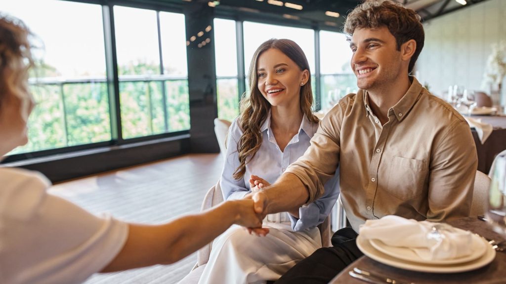 Man shaking hands with event coordinator in a wedding venue