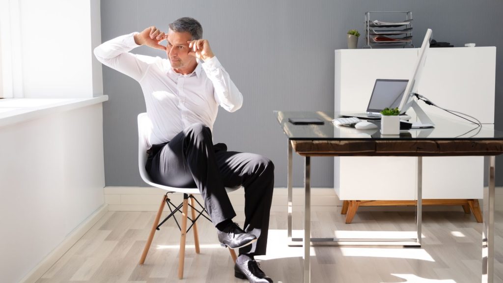 Man twisting his body while at the office