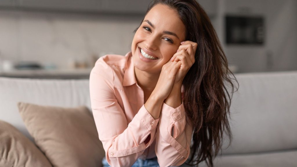 Radiant woman with contagious smile poses playfully