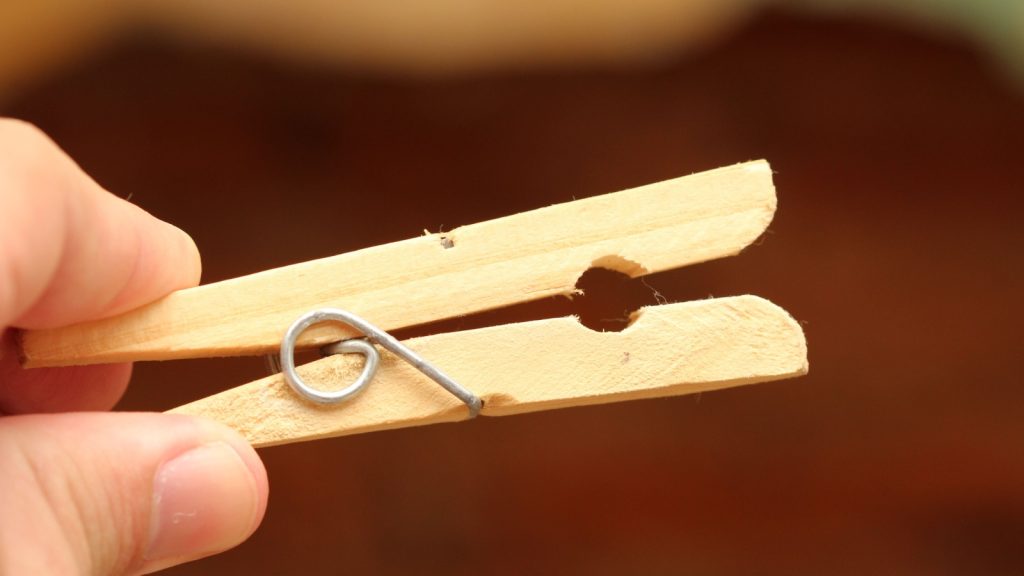 a clothespin made of wood with fingers on it