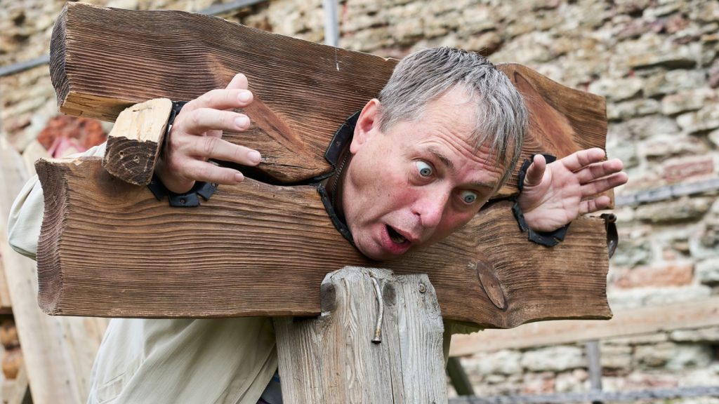 a man in a wooden pillory