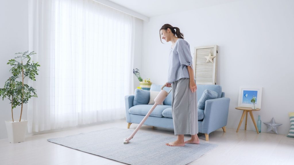 A woman vacuuming her carpet.