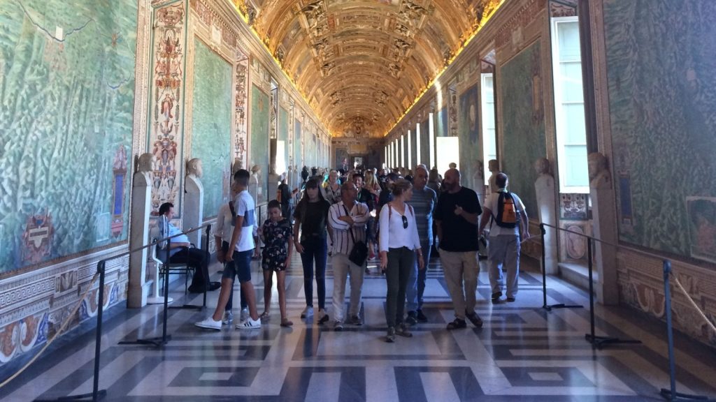 some people talking inside the Sistine Chapel