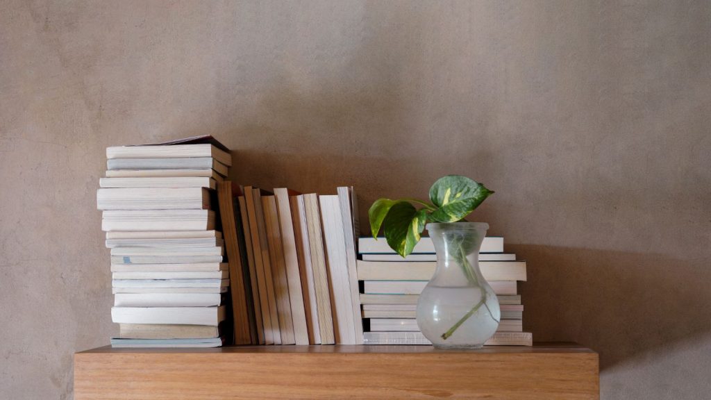 Stack of books on floating wooden bookshelf