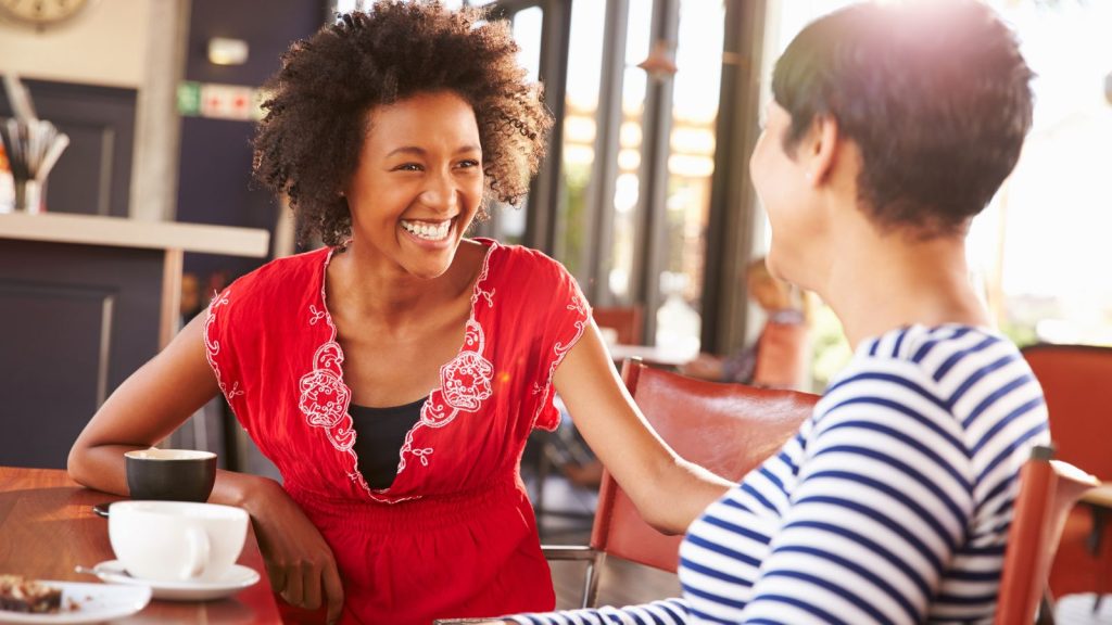 Two female friends talking at a coffee shop