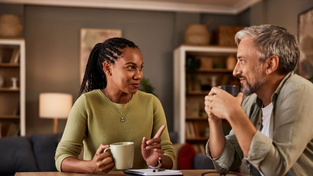 Two individuals in conversation while drinking coffee